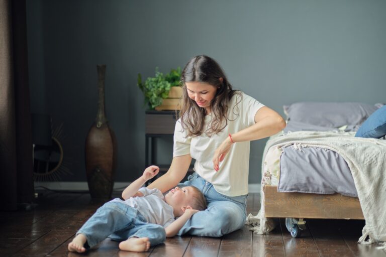 Son lies on her mother's lap, they smile. Family composition. Motherhood, maternity leave concept