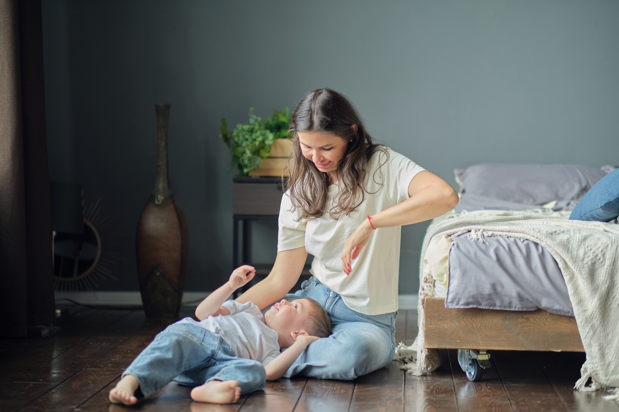 Son lies on her mother's lap, they smile. Family composition. Motherhood, maternity leave concept